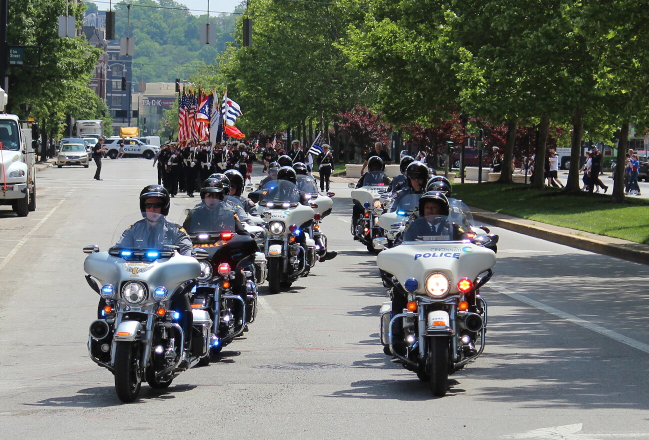 Police motorcyles lead a procession from Fountain Square.